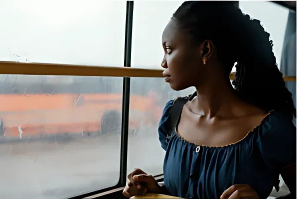 Mulher negra olhando pela janela.